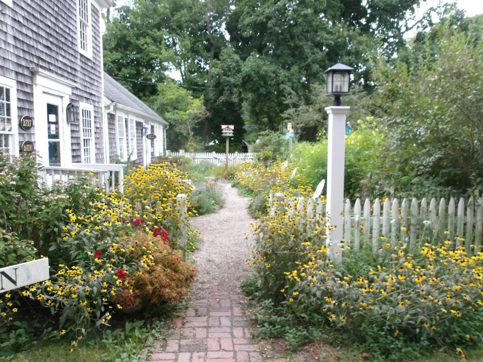 Brick garden path lined with yellow and red flowers