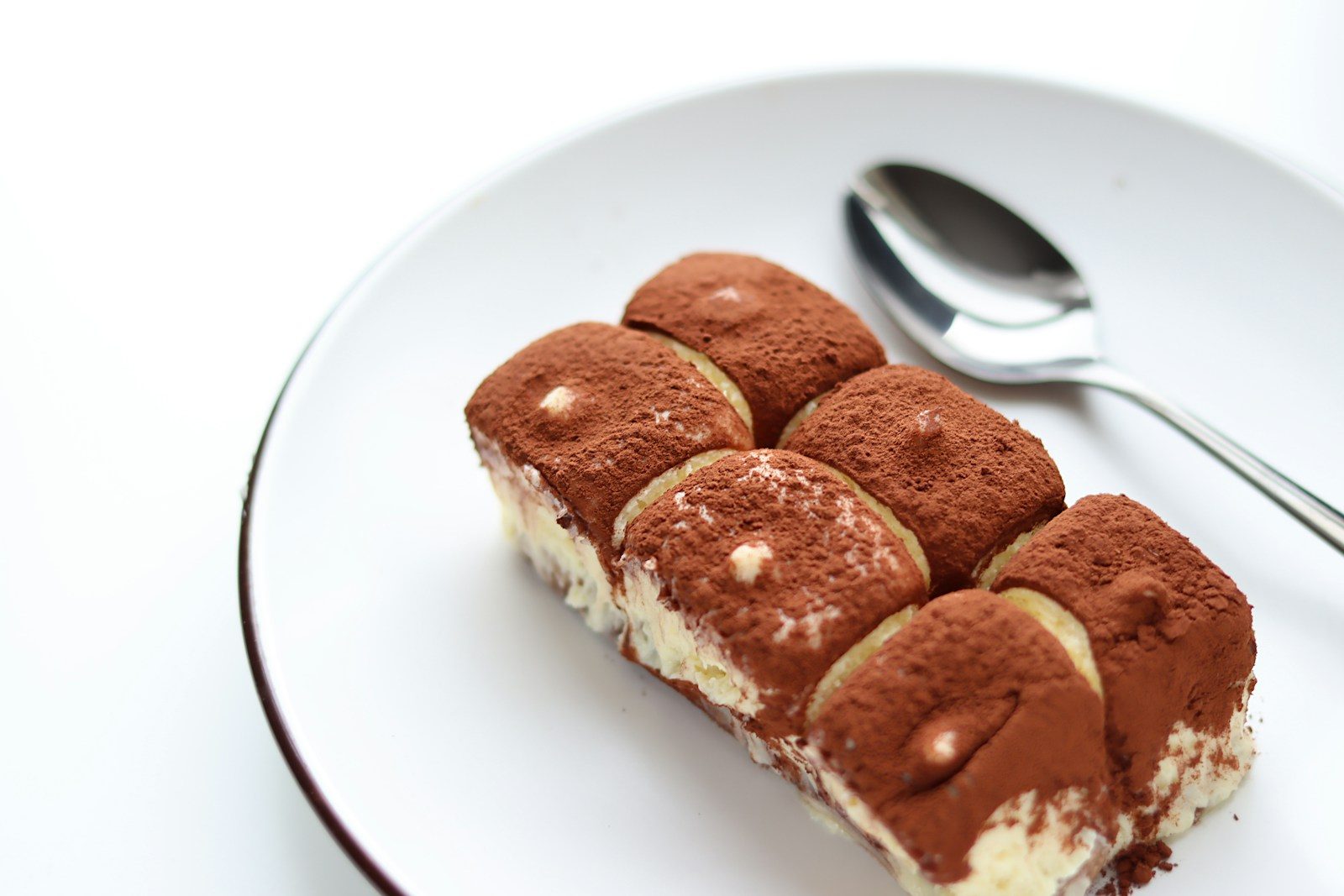 Tiramisu dusted with cocoa on a white plate